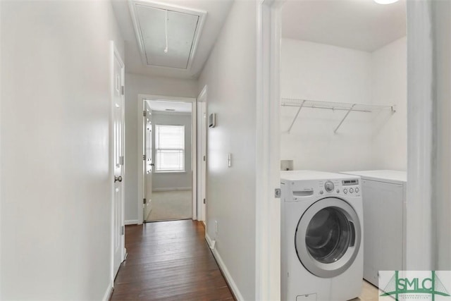 laundry area with baseboards, attic access, wood finished floors, and washing machine and clothes dryer