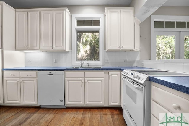 kitchen with a sink, white cabinets, white appliances, and a healthy amount of sunlight