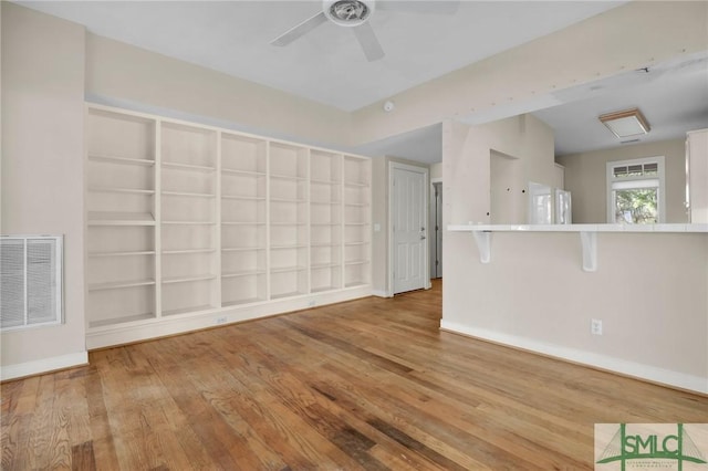 unfurnished living room with baseboards, a ceiling fan, wood finished floors, and visible vents
