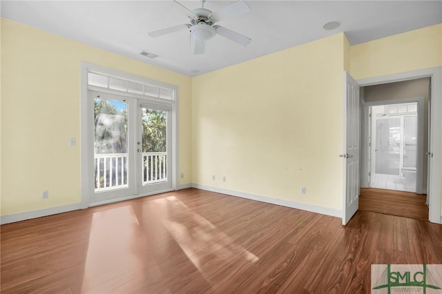 spare room featuring baseboards, a ceiling fan, and wood finished floors