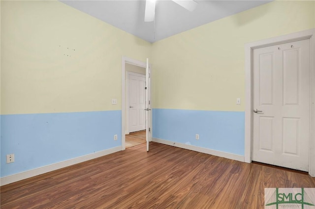 spare room featuring baseboards, ceiling fan, and wood finished floors