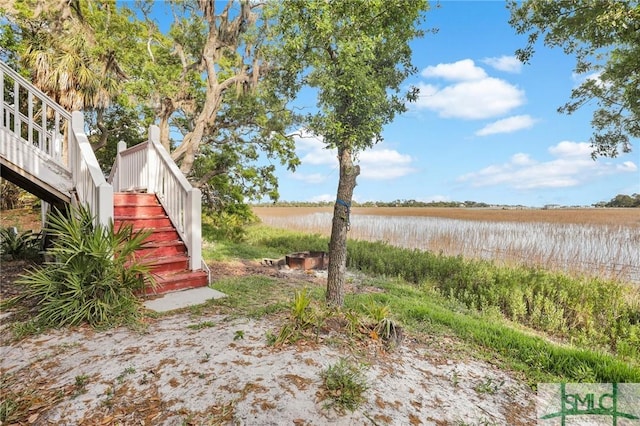 view of yard featuring a water view and stairway