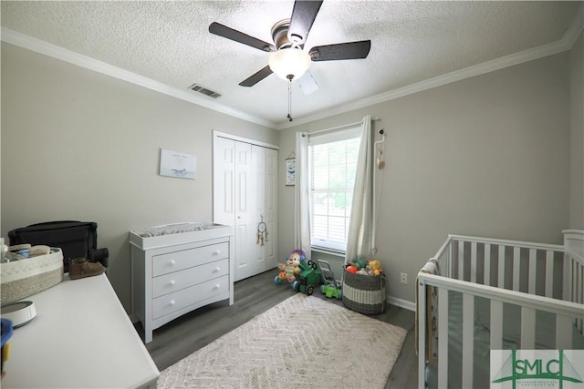 bedroom with a ceiling fan, a textured ceiling, visible vents, wood finished floors, and a closet