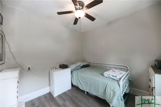 bedroom with a ceiling fan, baseboards, and wood finished floors
