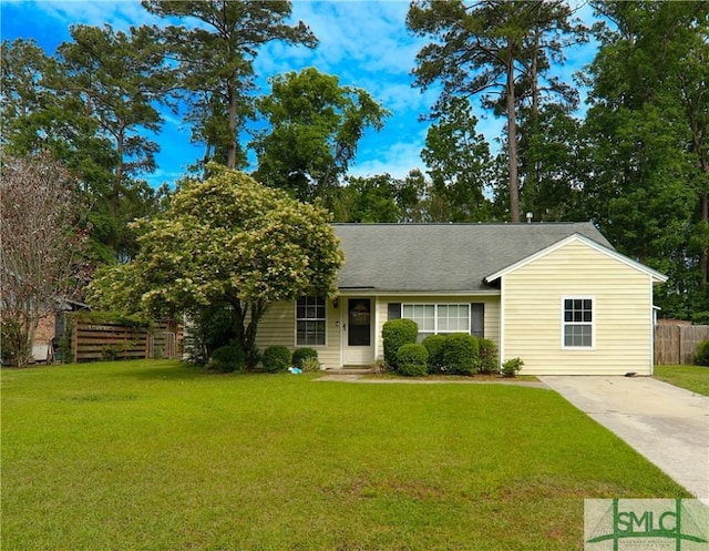 ranch-style house with concrete driveway, fence, a shingled roof, and a front lawn