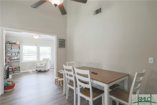 dining area with baseboards, ceiling fan, visible vents, and wood finished floors