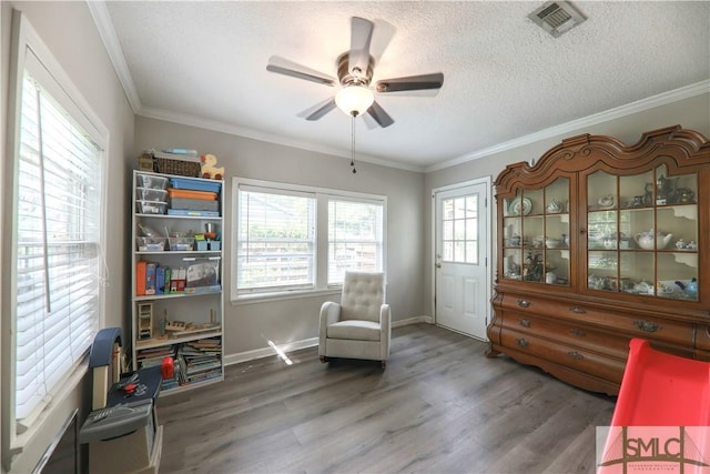 sitting room with visible vents, crown molding, wood finished floors, a textured ceiling, and a ceiling fan