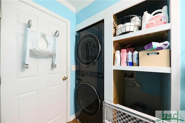 washroom with crown molding and stacked washer / dryer