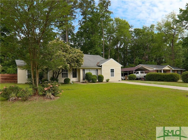 view of front of house with fence, driveway, a front yard, and a carport