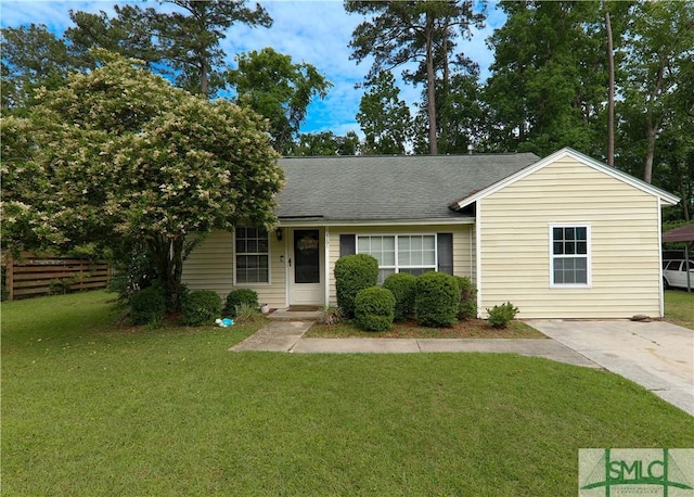 view of front of property featuring roof with shingles, fence, and a front lawn