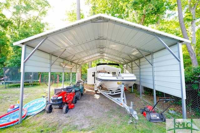 368 Piercefield Dr, Richmond Hill, GA 31324 - view of parking / parking lot featuring a detached carport, a trampoline, and a storage unit