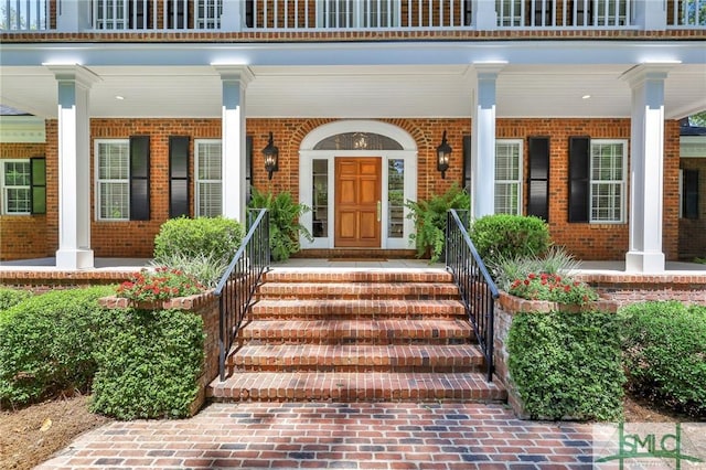 entrance to property with brick siding and covered porch