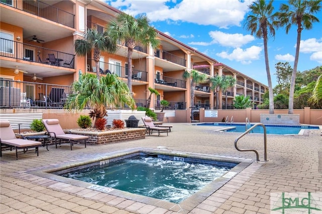 pool featuring a hot tub, fence, a ceiling fan, and a patio area