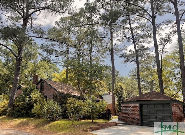 1901 E Anderson St E, Savannah, GA 31404 - view of front of home featuring brick siding, driveway, a chimney, and a detached garage
