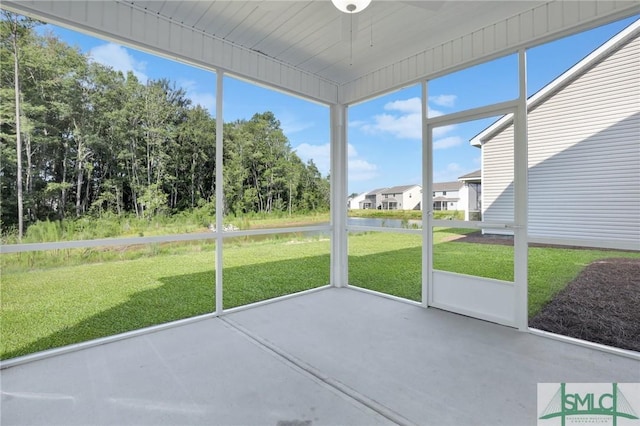 unfurnished sunroom featuring a water view and a ceiling fan