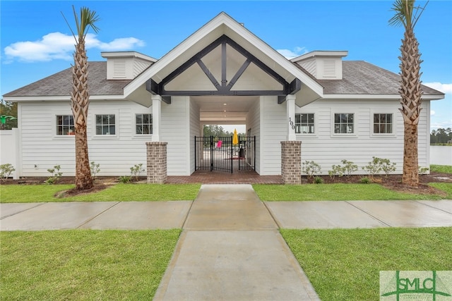 view of front facade featuring fence, a front lawn, and roof with shingles