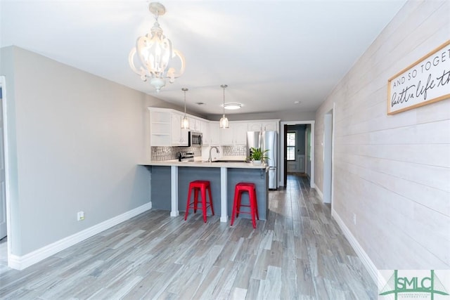 204 Archibald St, Rincon, GA 31326 - kitchen with appliances with stainless steel finishes, a peninsula, white cabinets, a chandelier, and open shelves