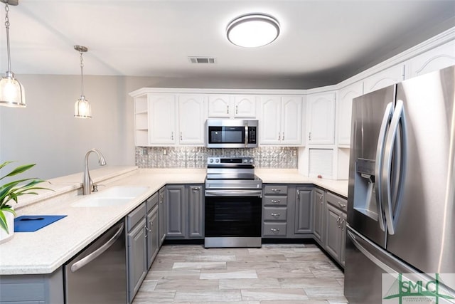 204 Archibald St, Rincon, GA 31326 - kitchen with stainless steel appliances, gray cabinets, a sink, a peninsula, and open shelves