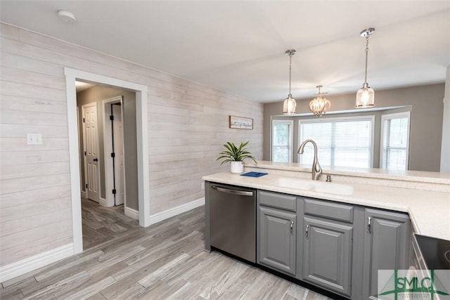204 Archibald St, Rincon, GA 31326 - kitchen featuring stainless steel dishwasher, a sink, gray cabinetry, wood walls, and light countertops