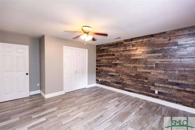 204 Archibald St, Rincon, GA 31326 - unfurnished bedroom with wood walls, wood finished floors, a closet, baseboards, and a ceiling fan