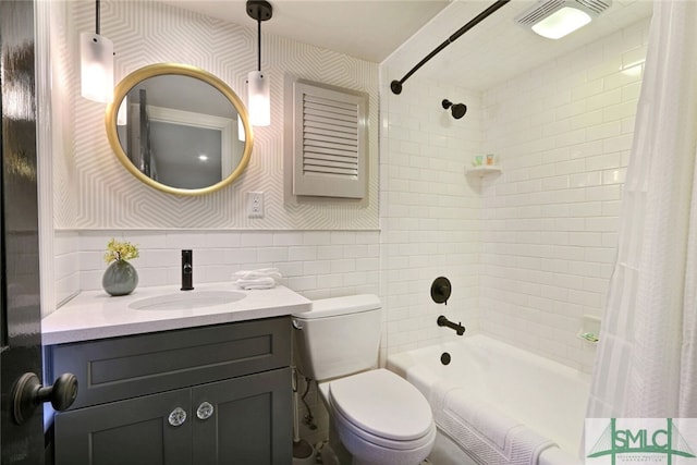 full bath featuring vanity, toilet, wallpapered walls, tile walls, and shower / tub combo