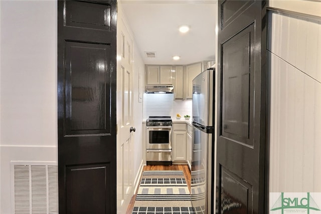 kitchen with visible vents, backsplash, under cabinet range hood, and stainless steel appliances