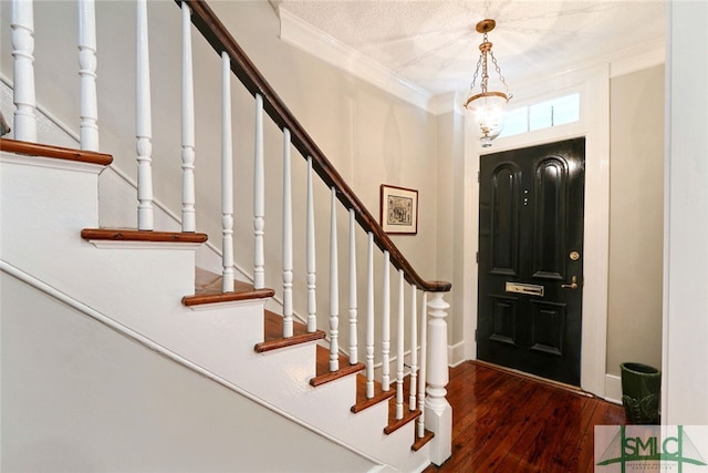 entryway featuring stairway, crown molding, and wood finished floors
