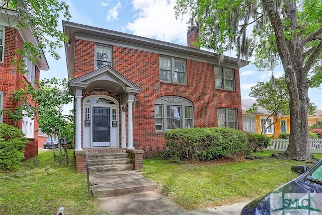 724 E 49th St, Savannah, GA 31405 - view of front of house with brick siding, a chimney, and a front lawn