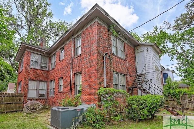 724 E 49th St, Savannah, GA 31405 - view of side of home featuring brick siding, central AC, and fence