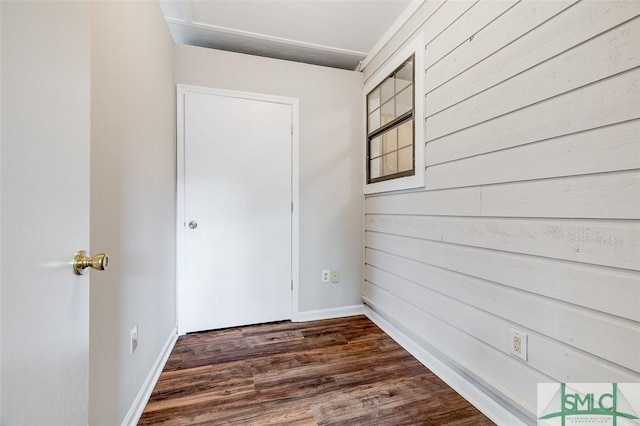 hall featuring baseboards and dark wood-style flooring