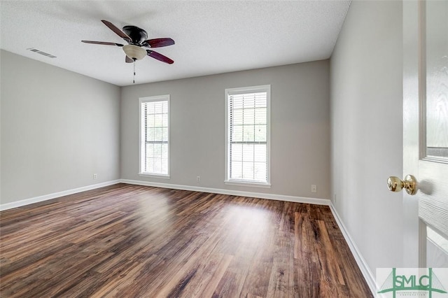 unfurnished room with visible vents, baseboards, ceiling fan, dark wood-style floors, and a textured ceiling
