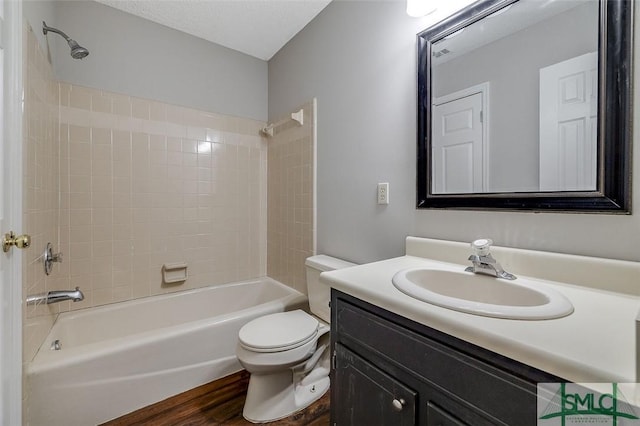 bathroom with toilet, shower / washtub combination, wood finished floors, and vanity