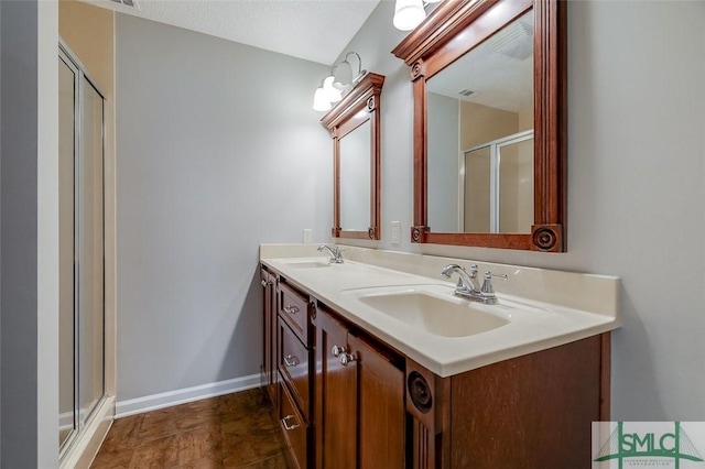 bathroom with double vanity, a sink, visible vents, and a shower stall