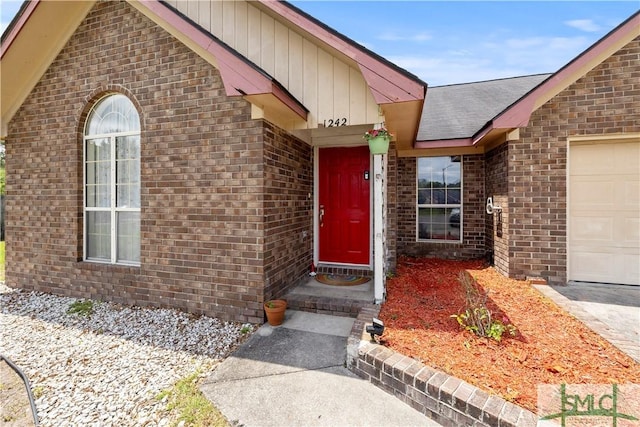 property entrance with brick siding and a garage