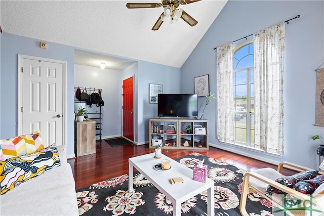 living area featuring baseboards, ceiling fan, wood finished floors, and high vaulted ceiling