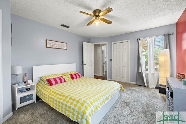carpeted bedroom with baseboards, ceiling fan, a textured ceiling, and visible vents