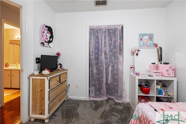 bedroom with visible vents, baseboards, and ensuite bath