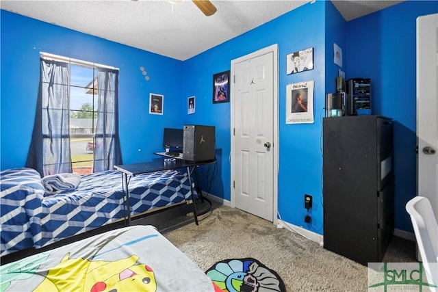 carpeted bedroom with a textured ceiling, baseboards, and ceiling fan