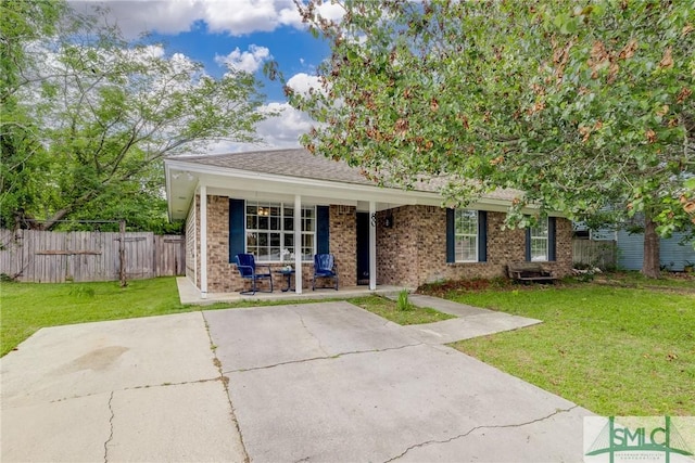 view of front of home with fence, a porch, a front lawn, and brick siding