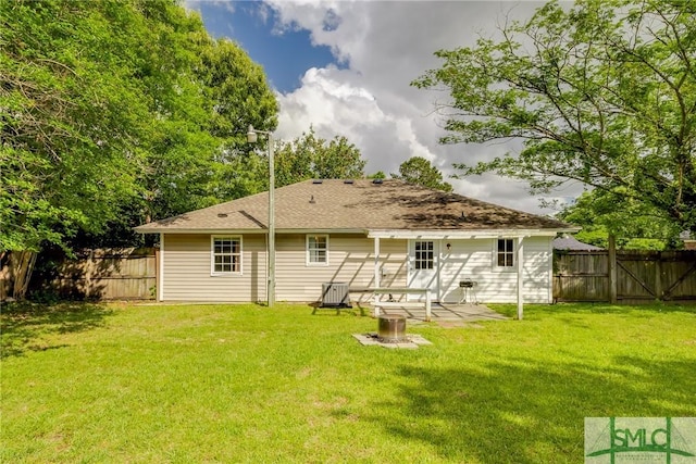rear view of house featuring a fenced backyard, a yard, and a patio area