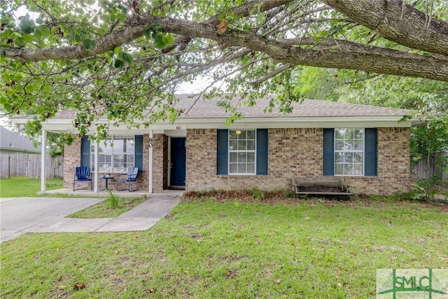 ranch-style house with covered porch, brick siding, fence, and a front yard