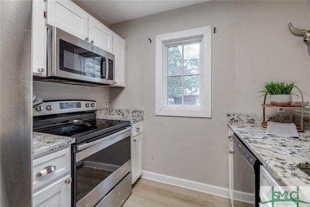 kitchen featuring light wood-style floors, baseboards, white cabinets, light stone counters, and stainless steel appliances
