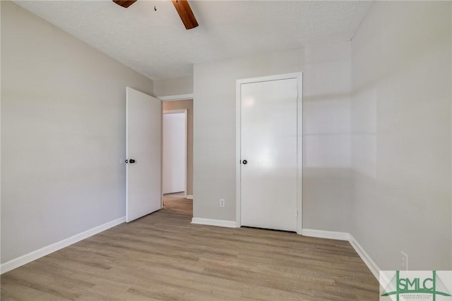 unfurnished bedroom featuring a ceiling fan, baseboards, and light wood-type flooring