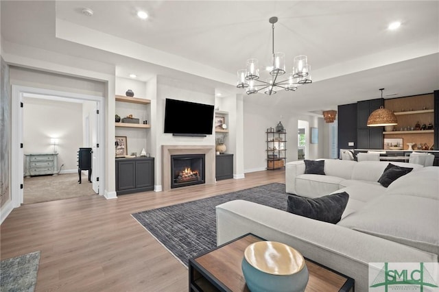 20 Serenity Pt, Savannah, GA 31419 - living area featuring baseboards, light wood-type flooring, a chandelier, and a warm lit fireplace