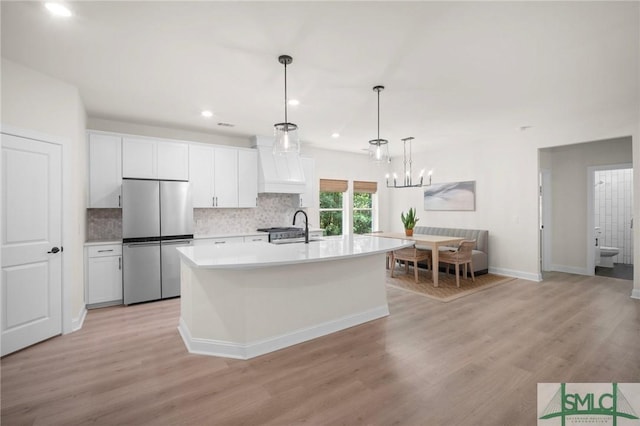 20 Serenity Pt, Savannah, GA 31419 - kitchen with freestanding refrigerator, light countertops, custom range hood, a sink, and light wood finished floors
