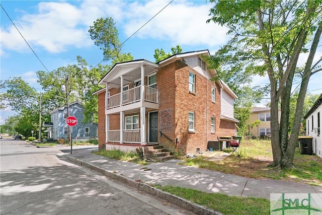 1145 Graydon St, Savannah, GA 31404 - view of side of home featuring brick siding, central AC unit, a balcony, and covered porch