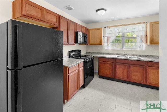 1145 Graydon St, Savannah, GA 31404 - kitchen with light tile patterned flooring, a sink, light countertops, visible vents, and black appliances