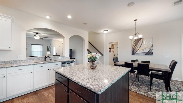 kitchen with a sink, stainless steel dishwasher, dark wood-type flooring, and visible vents
