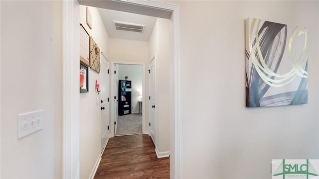 corridor featuring baseboards, dark wood-style flooring, and visible vents