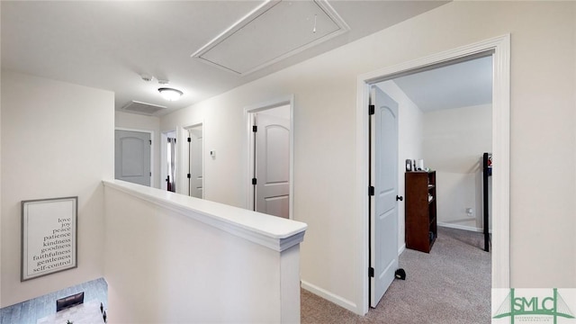 hall with baseboards, light carpet, attic access, and visible vents